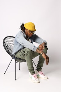 a man sitting on a chair wearing a yellow hat